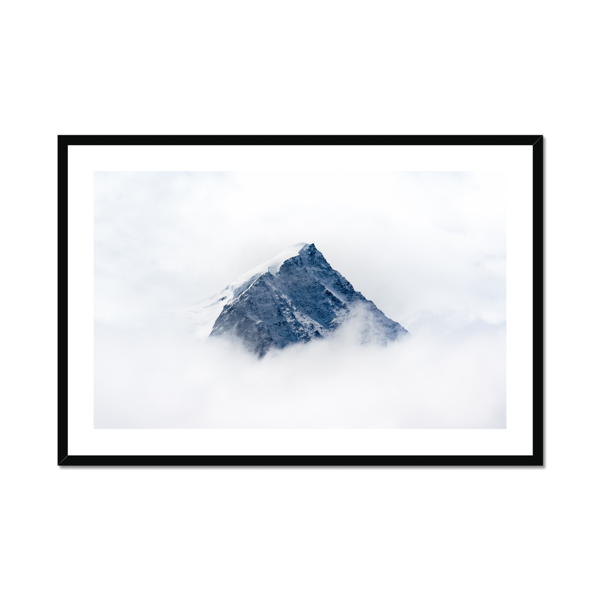 The image features a majestic, snow-capped mountain peak emerging from a dense layer of clouds against a pale sky, framed and ready for display.
